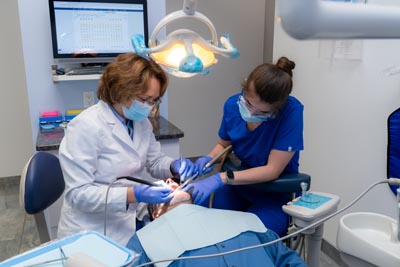 Dr. Kurudimova and her assistant providing emergency dental care for a patient at Dental Beauty in Feasterville, PA